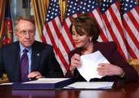 La presidenta de la Cámara de Representantes, Nancy Pelosi, y el jefe de la mayoría demócrata en el Senado, Harry Reid, firman una resolución sobre el financiamiento a la guerra de Irak