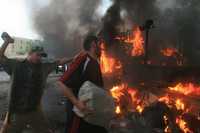 Residentes de la ciudad de Basora, en el sur de Irak, intentan apagar un camión en llamas. Hombres armados atacaron a policías iraquíes y soldados británicos. En la refriega perdieron la vida un agente y un militar