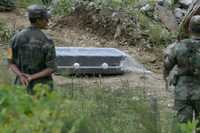 Un soldado observa uno de los ataúdes enviados por una empresa funeraria al lugar donde un autobús fue sepultado por un alud la mañana del miércoles en la Sierra Negra de Puebla