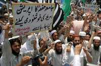 Militantes de un partido opositor islámico corean consignas contra el gobierno de Pervez Musharraf por la toma de la Mezquita Roja, durante una protesta en la ciudad paquistaní de Peshawar