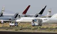 Bomberos y un equipo de rescate acuden a apagar las llamas de un avión que explotó en el aeropuerto de Mojave, California, accidente que causó la muerte de dos personas y heridas graves a otras cuatro en julio pasado