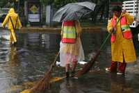 Trabajadoras del servicio de limpia de la ciudad realizan su labor bajo la lluvia, el miércoles pasado