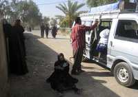 Mujeres iraquíes lloran cerca del vehículo que lleva el ataúd con el cuerpo de un familiar al depósito de cadáveres del hospital de Baquba