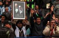 Una boliviana muestra un retrato con los ayatolas Jomeini y Jamenei, el viernes durante la visita de Ahmadinejad