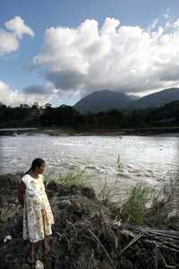 Una mujer observa el nuevo cauce del río, donde antes se encontraba su casa, en el poblado de Oxolotán, Tacotalpan. A dicha comunidad no ha llegado ayuda