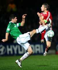 Fuerte disputa por el balón entre el danés Martin Jorgenson (derecha) y el irlandés Aaron Hughes, ayer en la eliminatoria de la Euro 2008