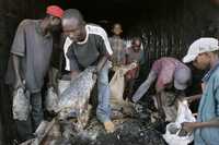 En Kericho, Kenia, habitantes recuperan pescado de un camión que fue atacado el viernes por un grupo armado