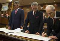 Fatmir Sejdiu, presidente de Kosovo (extremo derecho), firma el acta de independencia; lo acompañan Jakup Krasniqi, presidente del Parlamento (centro), y Hashim Thaci, el primer ministro