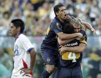 Juan Román Riquelme y Hugo Ibarra (4) felicitan a Martín Palermo, quien inauguró el marcador en el partido jugado en la cancha del Boca Juniors