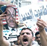 "El nuevo dictador", se lee en la incripción que porta un iraquí durante la protesta contra el primer ministro Nuri al-Maliki (foto en la otra mano del manifestante), la semana pasada en Bagdad