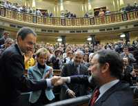 El derechista Mariano Rajoy (derecha) felicita en el Parlamento al presidente del gobierno español