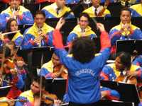 Gustavo Dudamel y su ejército de niños y jóvenes músicos, durante un concierto en México en 2007, en su ritual de despojarse del frac y quedar en atuendo deportivo con los colores nacionales de Venezuela