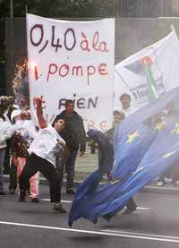 Un pescador arroja una bandera, durante una protesta frente a la sede de la Comisión Europea, en Bruselas. Pescadores de Francia, Italia y otros países  expresaron su ira por los elevados precios de los combustibles y demandaron el apoyo de la Unión Europea