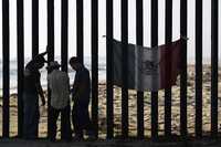 Una bandera mexicana cuelga de la valla que divide México y Estados Unidos en el área de Tijuana