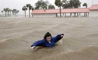 Una residente cruza las inundadas calles de la ciudad