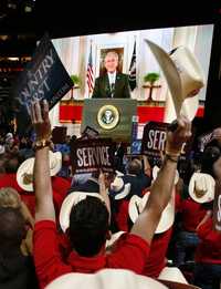 Delegados republicanos de Texas festejan la aparición en pantalla del presidente George W. Bush, quien no pudo asistir a la convención en Saint Paul, Minnesota, y pronunció su discurso vía satélite desde Washington