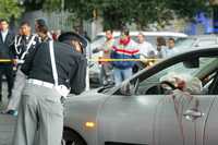 Un policía inspecciona el auto en el que fueron heridos dos asaltantes