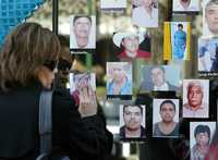 Familiares y amigos de los mineros muertos en Pasta de Conchos rezan ante las fotografías de ellos durante la misa mensual que realizan afuera de las oficinas del Grupo Minero México, ayer