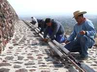 Trabajadores retiran las canaletas instaladas en una de las pirámides de la zona arqueológica, en imagen captada ayer