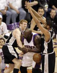 Matt Bonner (izquierda), de Spurs, comete una falta contra Shaquille O`Neal, de Suns (al centro), durante un partido de basquetbol de la NBA realizado en Phoenix