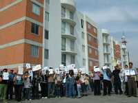 Vecinos del fraccionamiento Residencial de las Fuentes, en Tultitlán, estado de México, muestran documentos que amparan la compra de sus viviendas