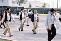 Felipe Calderón Hinojosa, rodeado por elementos del Estado Mayor Presidencial, al salir de una fábrica en Querétaro, durante su gira por la entidad