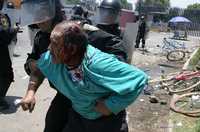 Por segundo día consecutivo, el gobierno poblano usó la fuerza pública contra manifestantes. En la imagen, policías antomotines detienen a uno de los habitantes de Santa Ana Xalmimilulco que exigían el cierre de una empresa que incinera residuos tóxicos