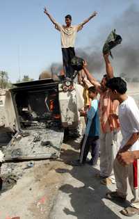 Iraquíes festejan tras el ataque a un vehículo militar en el que murió un soldado danés cerca de la ciudad de Basora