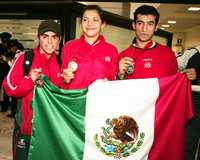 Rodolfo Osornio, ganador de bronce (izquierda), y Guillermo Pérez, medallista de plata, flanquean a María del Rosario Espinoza, a su llegada esta madrugada de Pekín