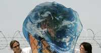 Un grupo ambientalista alemán llamado BUND sostiene un globo terráqueo que se derrite como señal de protesta por la emisión de gases de efecto invernadero y las consecuencias sobre el calentamiento global, cerca del lugar donde se reunirán los líderes del G-8