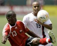 El trinitario Christon Baptiste controla el balón ante el estadunidense Ricardo Clark, durante el partido que EU ganó 2-0 a Trinidad y Tobago