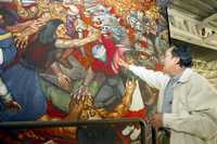 Ariosto Otero muestra a La Jornada un fragmento de los tres murales que pintó en la plazacomercial Merced 2000