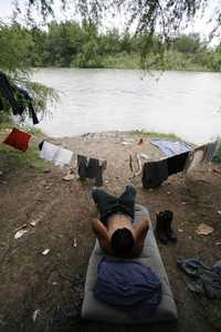 Un migrante espera el momento de cruzar el río hacia Estados Unidos, cerca de la ciudad fronteriza de Reynosa