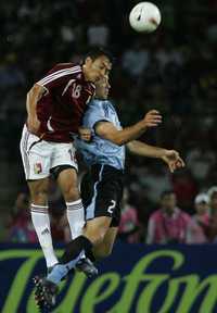 Juan Arango, del equipo anfitrión (izquierda) disputa el esférico con el uruguayo Diego Lugano * Ap