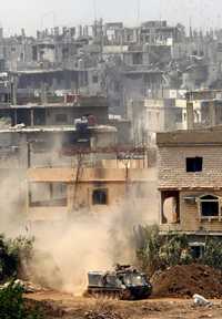 Edificios destruidos por artillería libanesa se observan al fondo mientras en primer plano tropas del ejército ingresan al campo de refugiados de Nahr al-Bared, en la ciudad norteña de Trípoli, como parte del asalto que comenzó hace cuatro días para desmantelar al grupo Fatah al-Islam