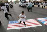 Un niño iraquí baila sobre una bandera estadunidense al participar ayer, en Basora, en una ceremonia para conmemorar el tercer aniversario del asesinato del líder religioso chiíta Ali Al-Hadi