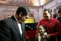 Hugo Chávez, presidente de Venezuela (a la derecha), le presenta a su par de Ecuador, Rafael Correa, a una menor en una ceremonia realizada ayer en una iglesia de Quito
