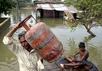 Una inundación en el pueblo Balrampur, al norte de la India, dejó cientos de damnificados, lo que obligó a las autoridades a cancelar vacaciones de doctores para atender la emergencia. En la imagen, una familia abandona su casa anegada