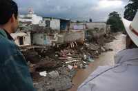 Habitantes de la colonia Plan de Ayala, en Tulancingo, Hidalgo, observan viviendas destruidas por el paso del huracán Dean. En la siguiente imagen, varios vehículos quedaron atrapados en un deslave ocurrido cerca de Ahuacatlán, Puebla