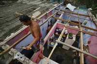 Un residente de Tecolutla, Veracruz, repara el techo de su vivienda, destruido por el paso del huracán Dean