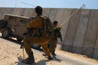 Soldados israelíes remueven una cuerda utilizada por dos palestinos para saltar el muro en Erez