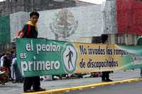 Durante el segundo Foro del Peatón, en el Zócalo capitalino, algunos jóvenes mostraron en pancartas los derechos del transeúnte