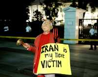 "Mi siguiente víctima es Irán", reza el rótulo que mostró un manifestante disfrazado de George Bush, la noche del jueves frente a la Casa Blanca
