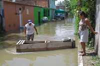 Una pareja de damnificados se prepara a abordar una lancha para llegar a su casa inundada, en la ciudad de Tixtla, Guerrero, que desde hace una semana se encuentra bajo el agua por el desbordamiento de la Laguna Negra