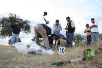 Funcionarios guanajuatenses examinan el sitio en que se encontró el cuerpo de un individuo ejecutado ayer por la madrugada en Acámbaro