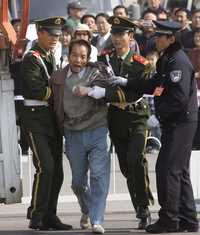 Policías arrestan a un hombre afuera del Gran Palacio del Pueblo, en Pekín, que gritaba consignas como "abajo la corrupción" durante el desarrollo del congreso partidista