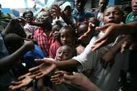 Niños haitianos damnificados por Noel reciben ayuda en una escuela ubicada en Ciudad Soleil, en la periferia de Puerto Príncipe