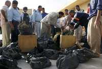 Iraquíes examinan bolsas con restos humanos hallados en la periferia de la capital