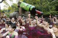 El código del brindis es tan firme que se presta al símbolo, a la señal ominosa, al principio de la destrucción. Arriba, visitantes del spa Beaujolais Noveau celebran la apertura del lugar con un baño de vino del mismo nombre, en Hakone, Tokio