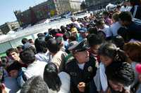 Un policía trata de contener a las personas que pretendían ingresar a las gradas para observar espectáculos como Vaselina, de patinaje artístico y botargas en la pista de hielo instalada por el GDF en la parte sur de la explanada del Zócalo